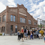 Grupa ludzi stoi przed budynkiem należącym do Muzeum Śląskiego.