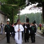 Procesja Bożego Ciała idzie ulicami miasta.