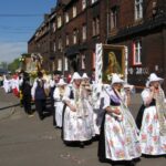 Procesja Bożego Ciała idzie ulicami miasta.