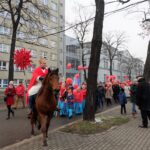 Mężczyzna jedzie na koniu i prowadzi orszak.