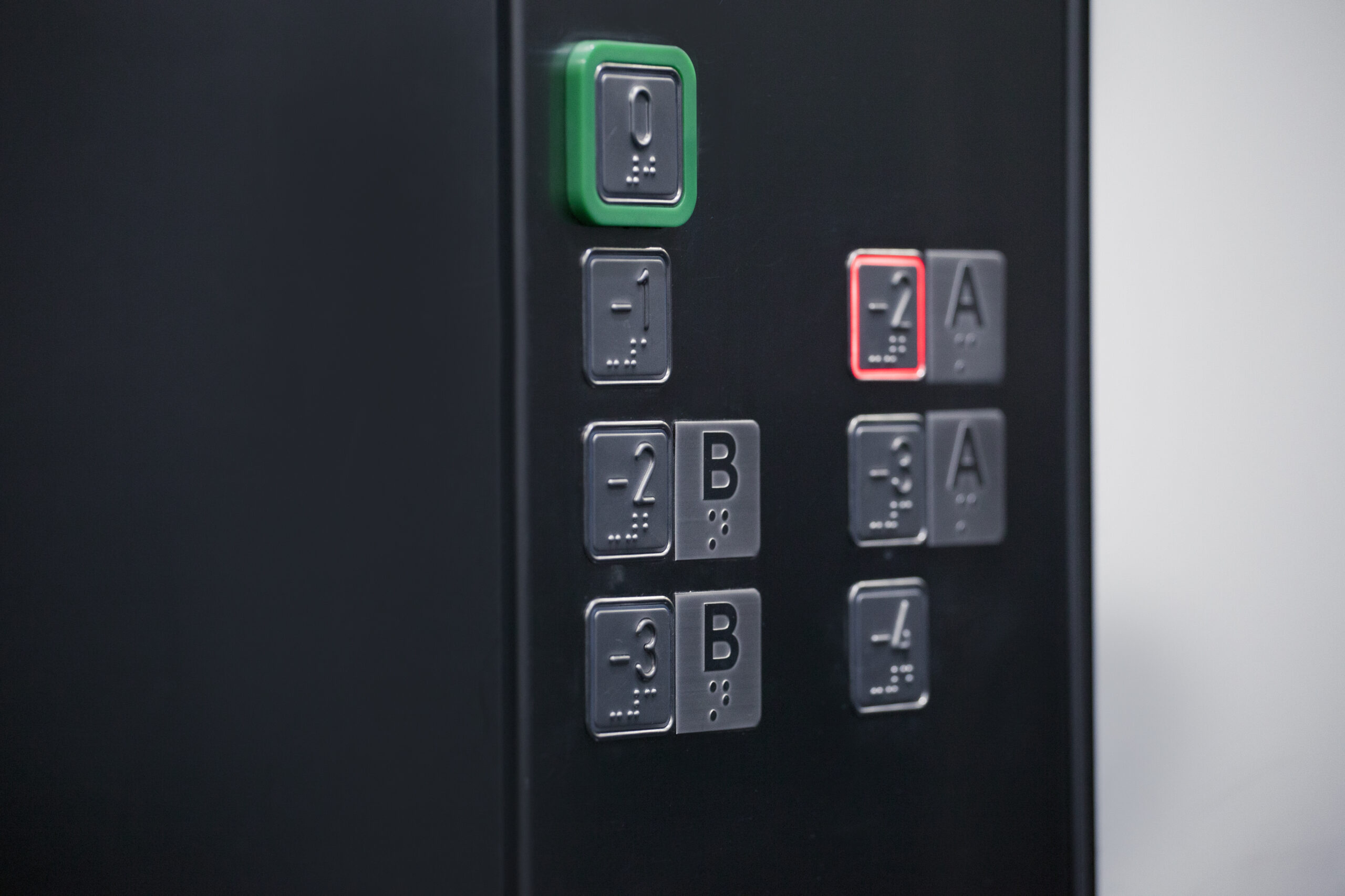 Panel sterujący windą z przyciskami numerycznymi i literami. Przyciski oznaczone są alfabetem Braille'a.